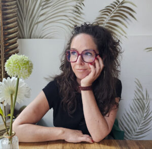 Wendy portret wegkijken bloem op tafel frisse kleuren achterkant boek